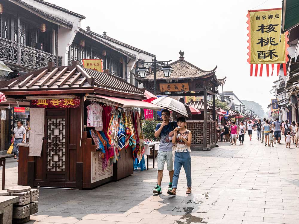 The Travel Intern – Locals walking under an umbrella in He Fang Street, Hangzhou