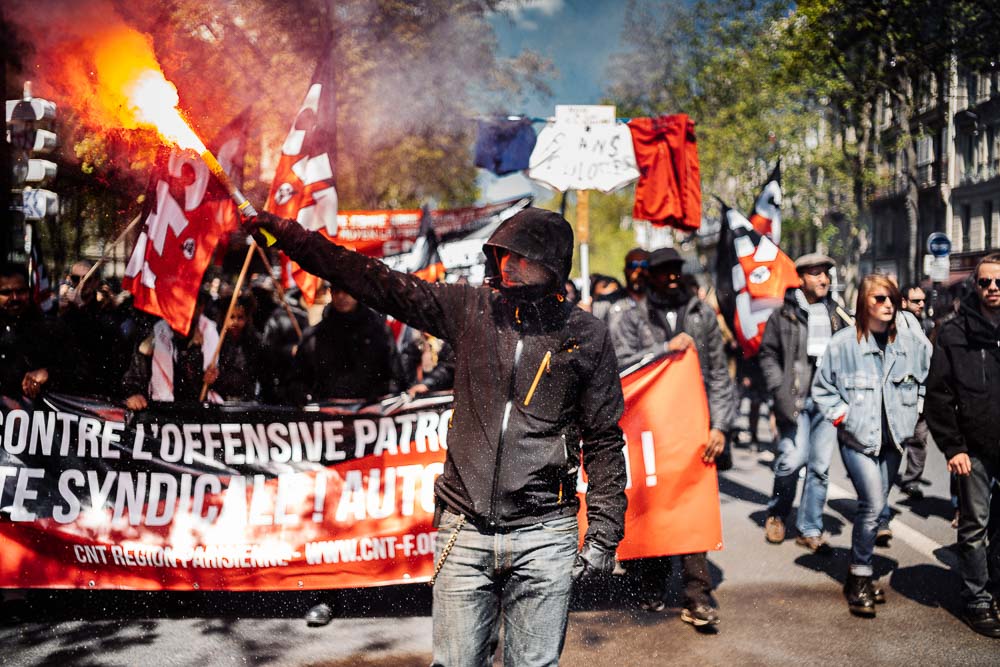 Protestor marches with a flare - Travel photojournalism