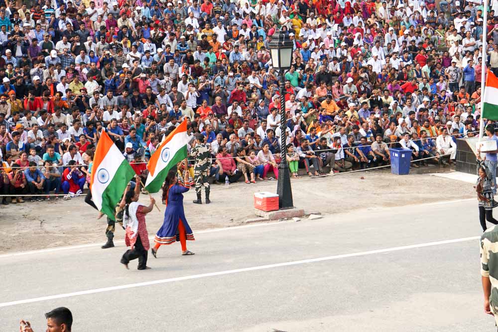 Locals bearing the flag and running across the stage during the Wagah Border Ceremony