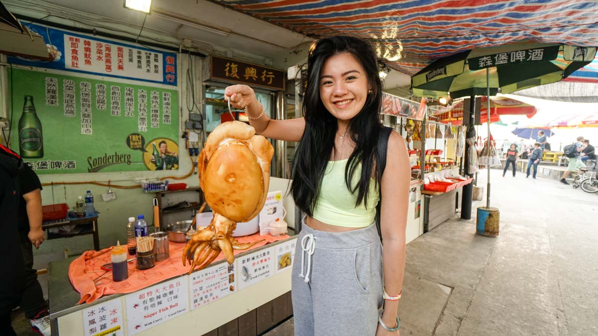 Posing for a photo graph with the grilled squid - hong kong food journey 13