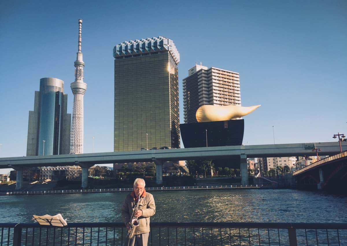Older gentleman serenading us with his saxophone along Sumida River Terrace - love in tokyo 15