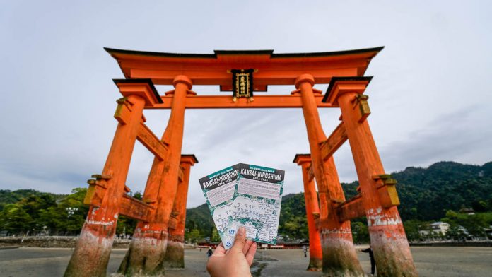 Holding up the Kansai-hiroshima JR Pass against the Miyajima Torii gate - Japan JR Pass guide - Singapore