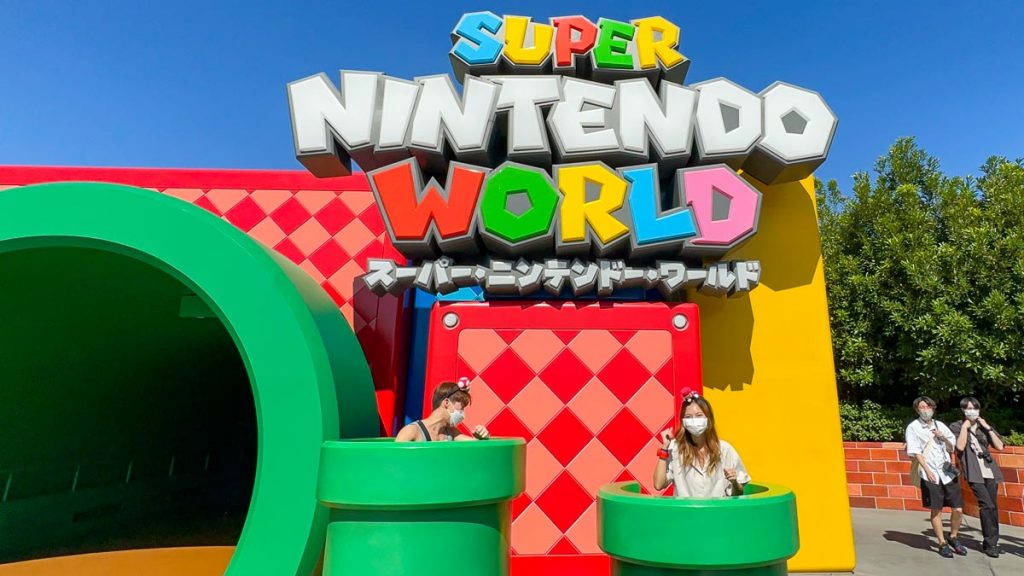 Menina e menino na entrada do Super Nintendo World - Guia de transporte de Osaka