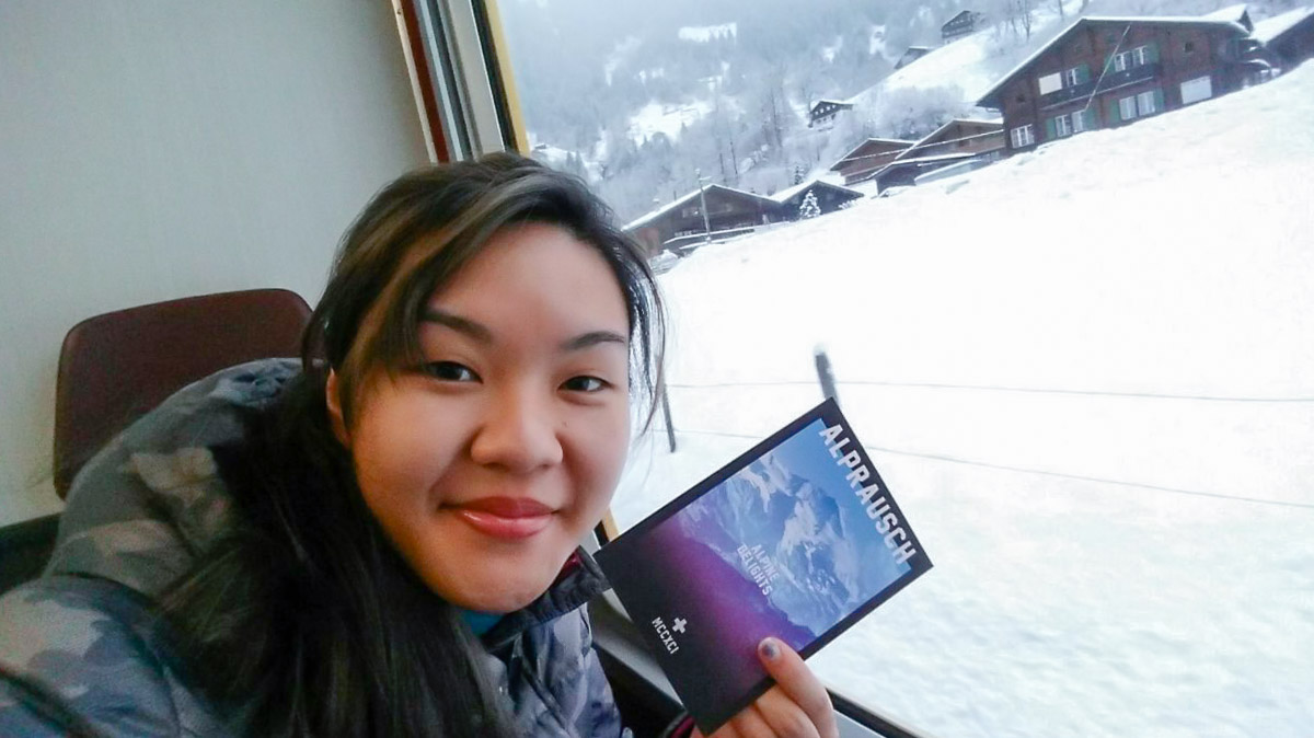 Posing with postcard on train in Switzerland - Europe Under S$2500