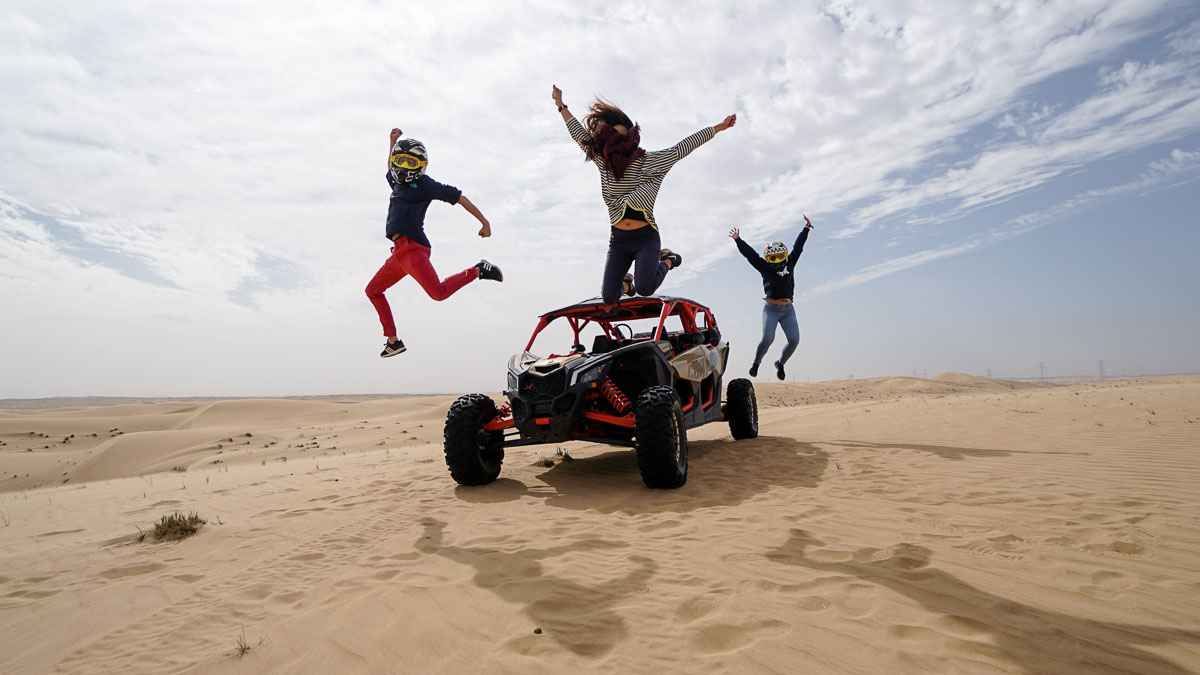 TTI team jumping off dune buggy - Dubai itinerary