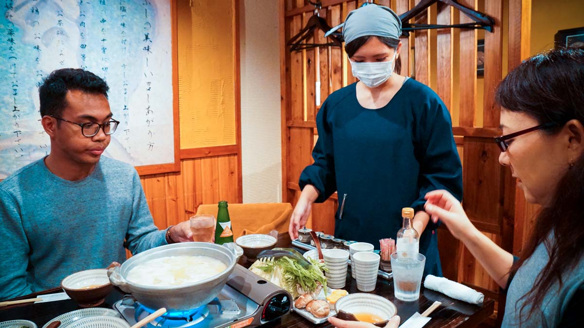Waitress explaining how to enjoy Tori mabushi restaurant - Japan Kyushu Itinerary