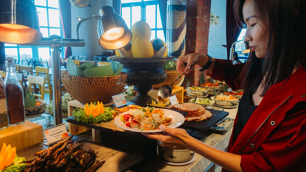 Woman scooping food at Arapang Buffet - Central Vietnam Itinerary