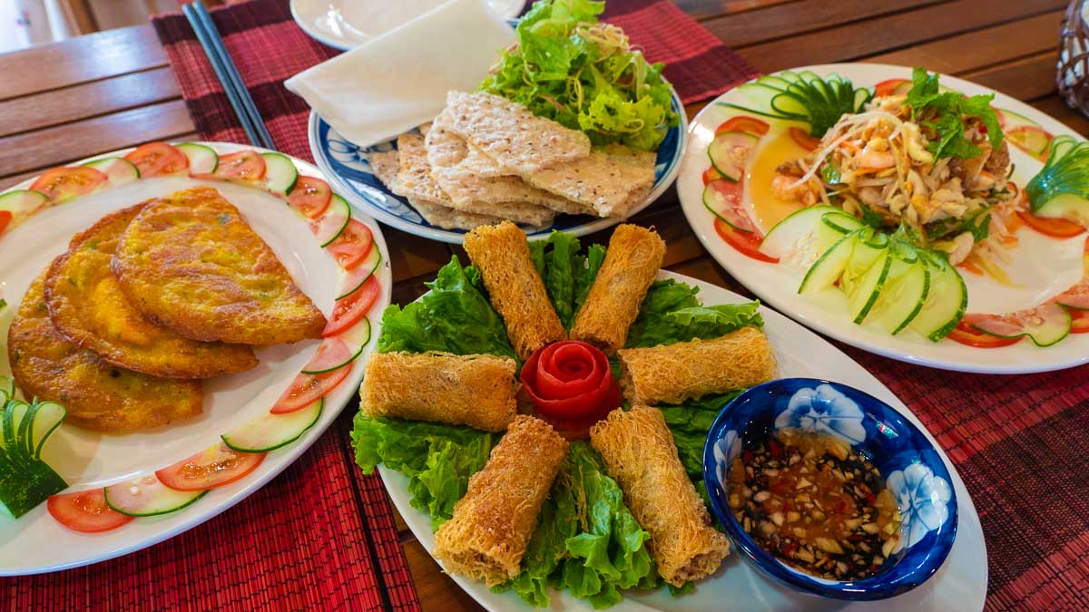 spread of fried spring rolls, banh xeo  and fresh coconut - Central Vietnam Itinerary