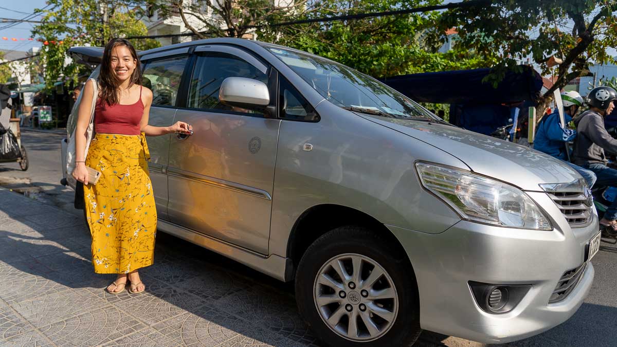 Girl next to a large car - Central Vietnam Itinerary