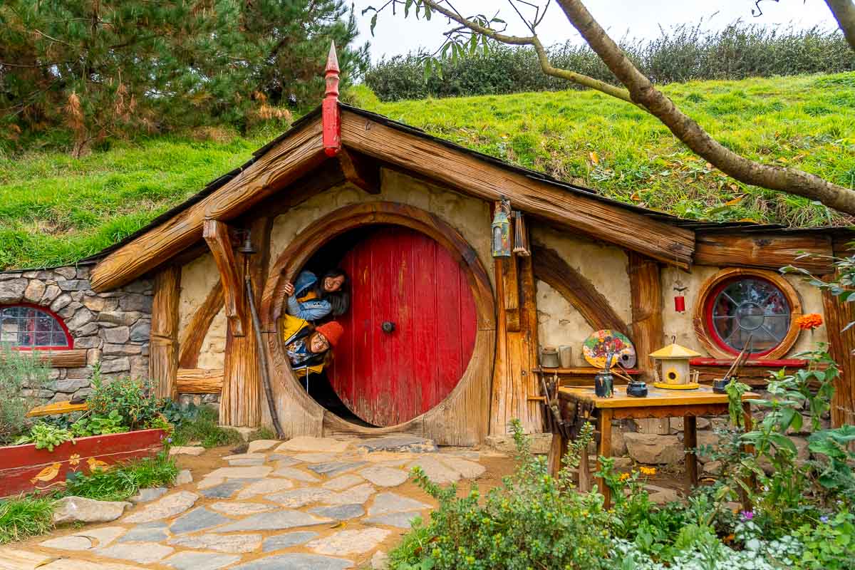  Spähen aus Hobbit Hole bei Hobbiton Movie Set Tour - Neuseeland Reiseroute Nordinsel