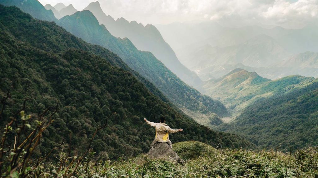 Sitting on a rock on Fansipan - Solo Travel Guide