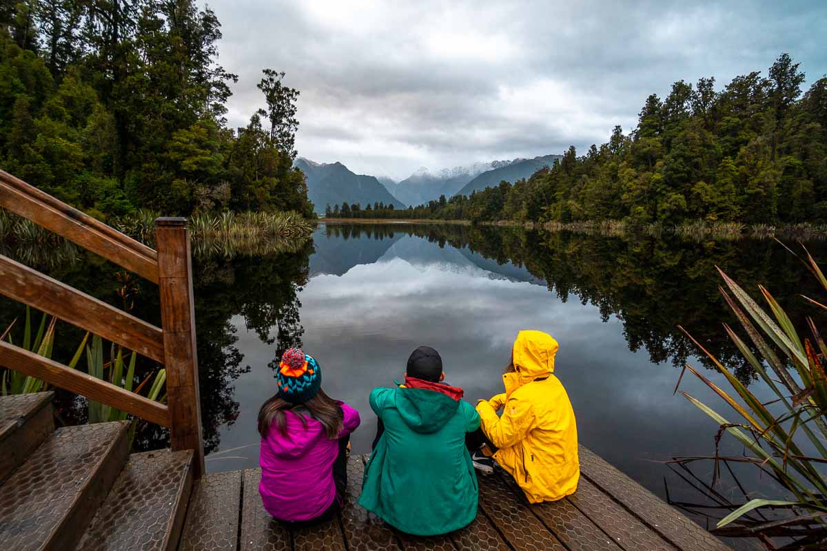 Sitting at Lake Matheson - New Zealand Best Things to Do
