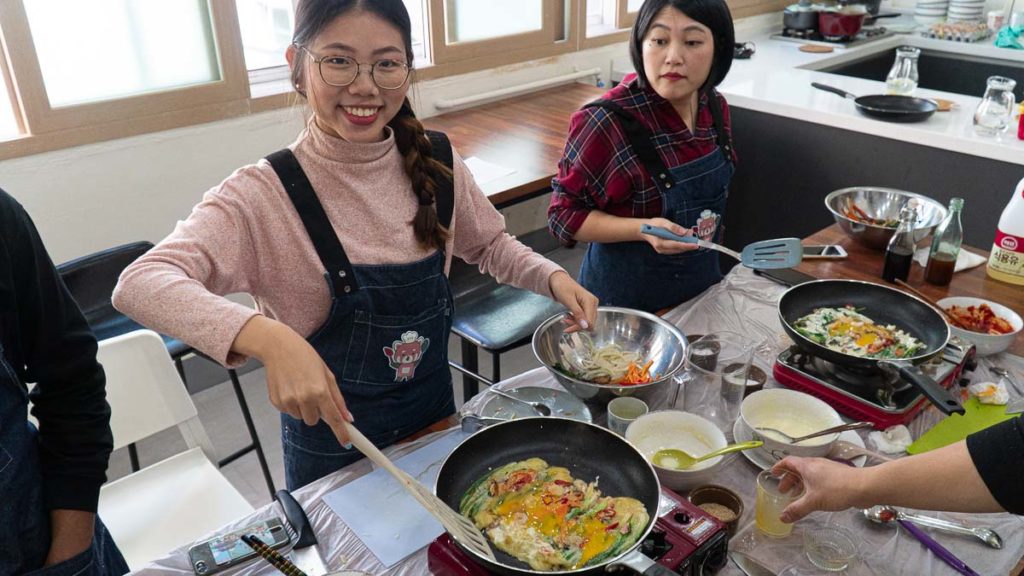 Girl cooking Korean food - Things to do in Korea