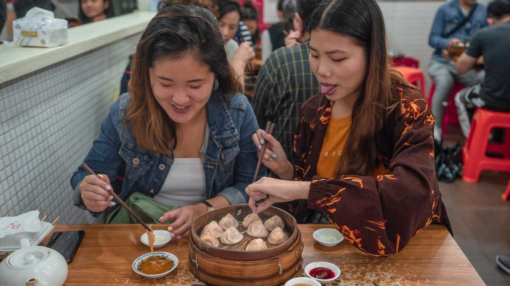 Two girls eating xiao long bao