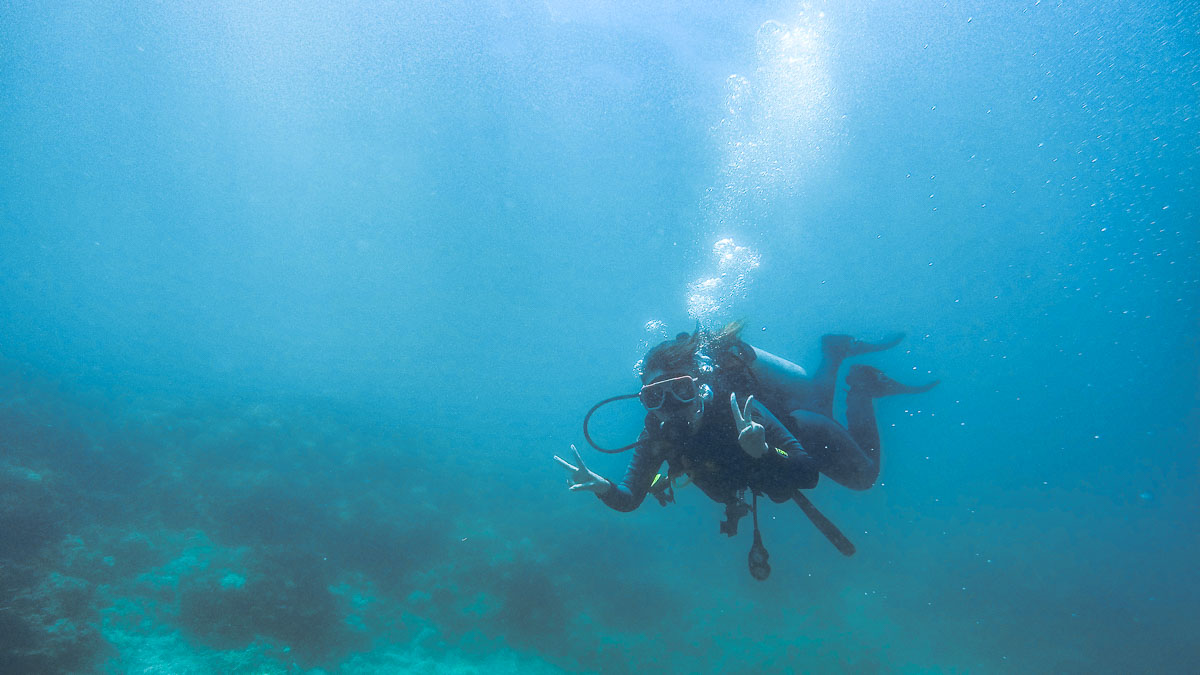 Girl diving and posing for photo under water - things to do in Palawan