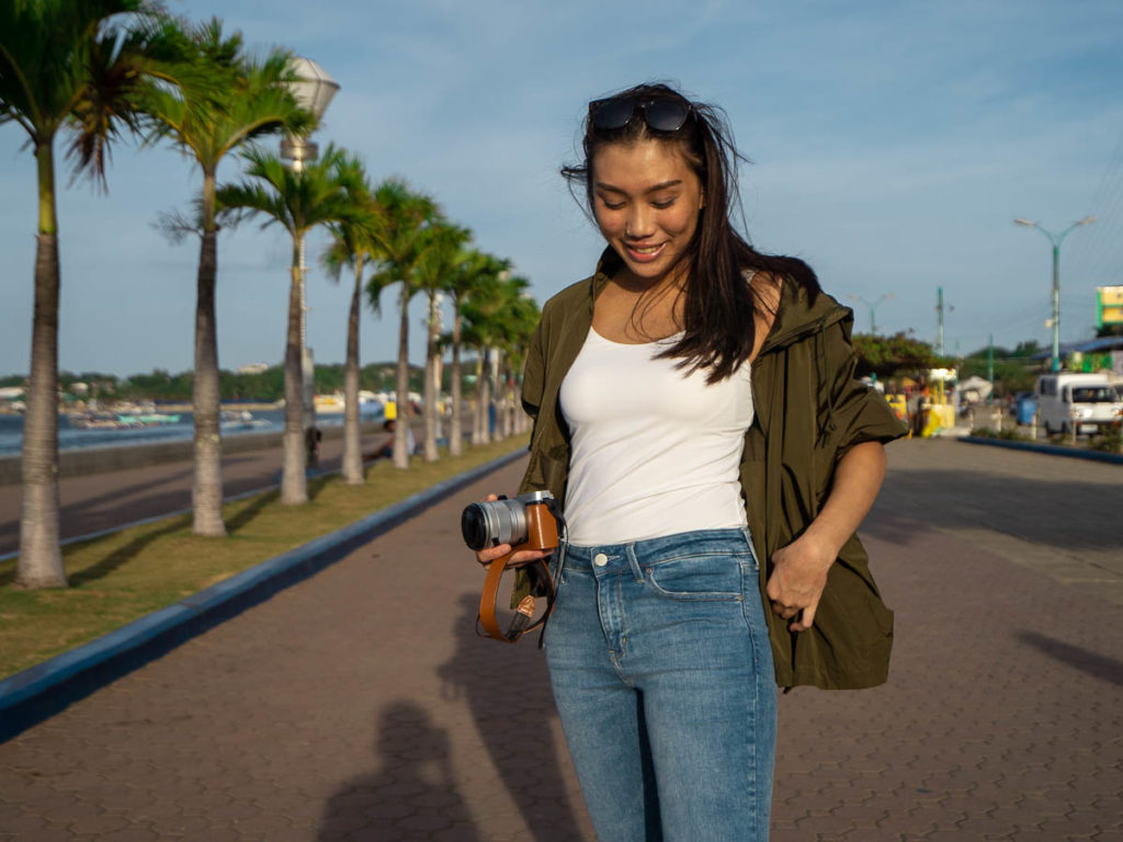 Girl posing for a picture along the line of palm trees at Baywalk - Puerto Princesa Itinerary