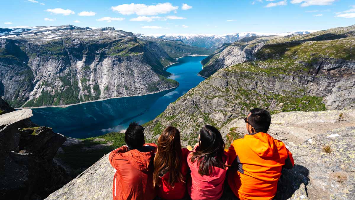 Friends overlooking the scenic view at Trolltunga, Norway