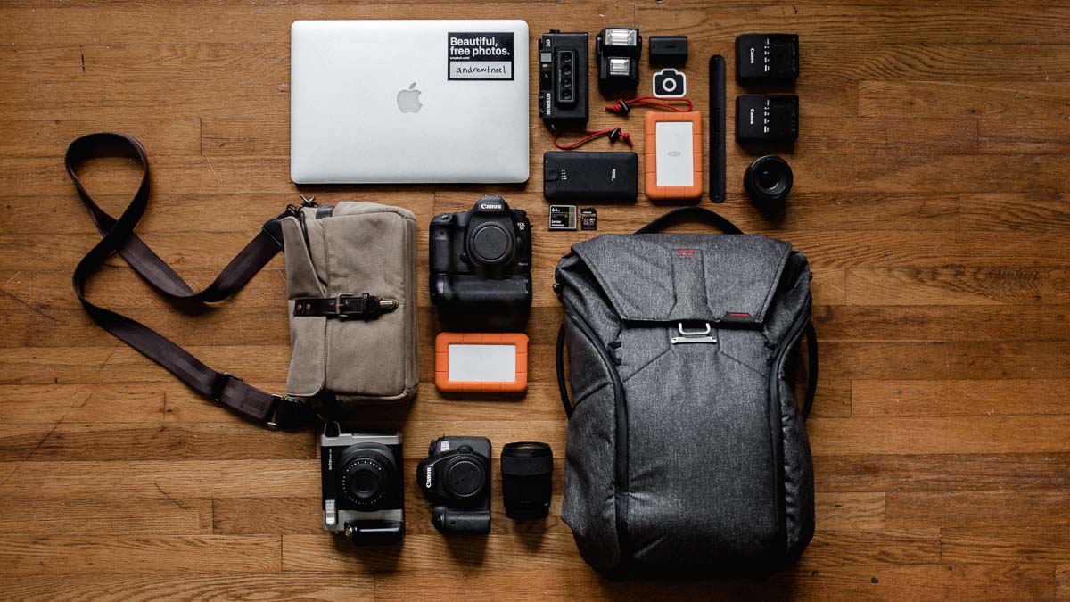 Flat lay of travel gear like cameras and laptop - Travel laptops in 2020