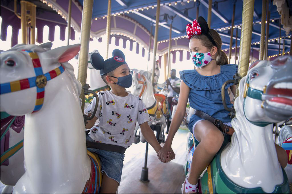 Guests with masks on in Disneyland Orlando - Theme parks reopen after COVID