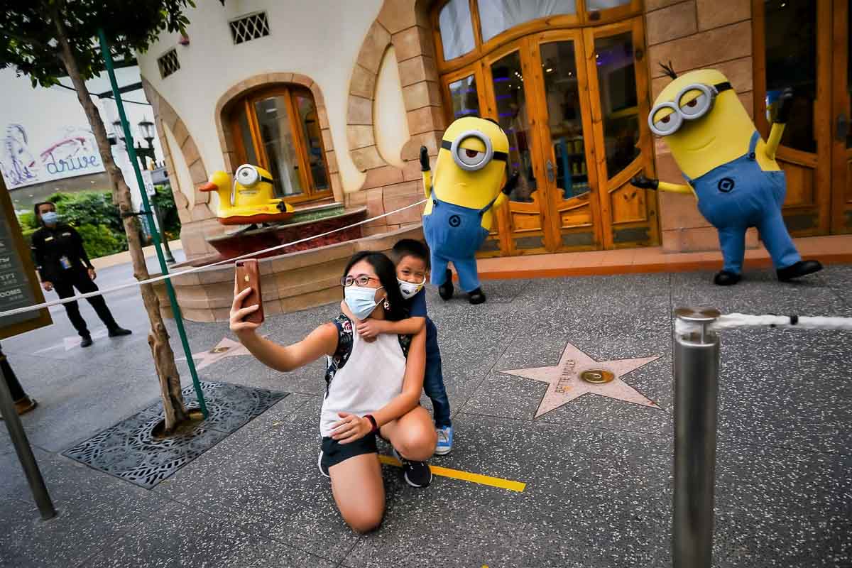 Universal Studios Singapore guests with masks on - Theme Parks Reopen Around the World