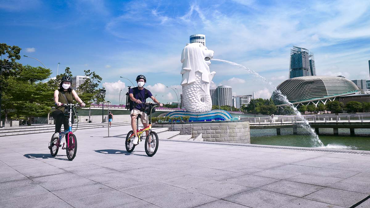 Girl and guy on a bicycle near Merlion Park