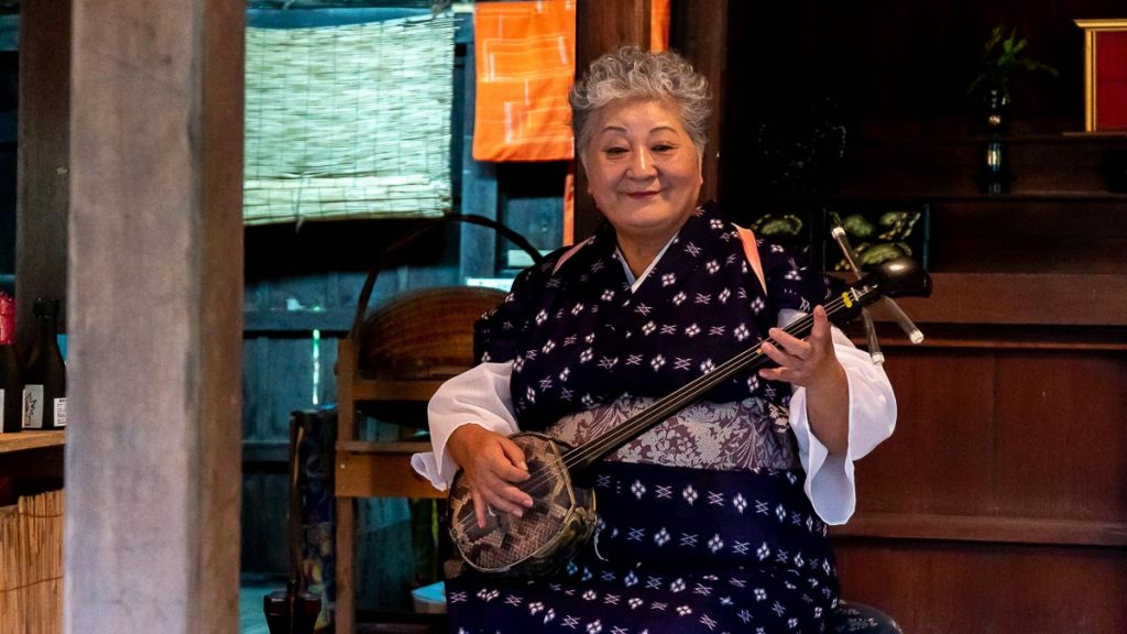 Sanshin performer in Ryukyu Mura - cultures explained Okinawa different from Japan