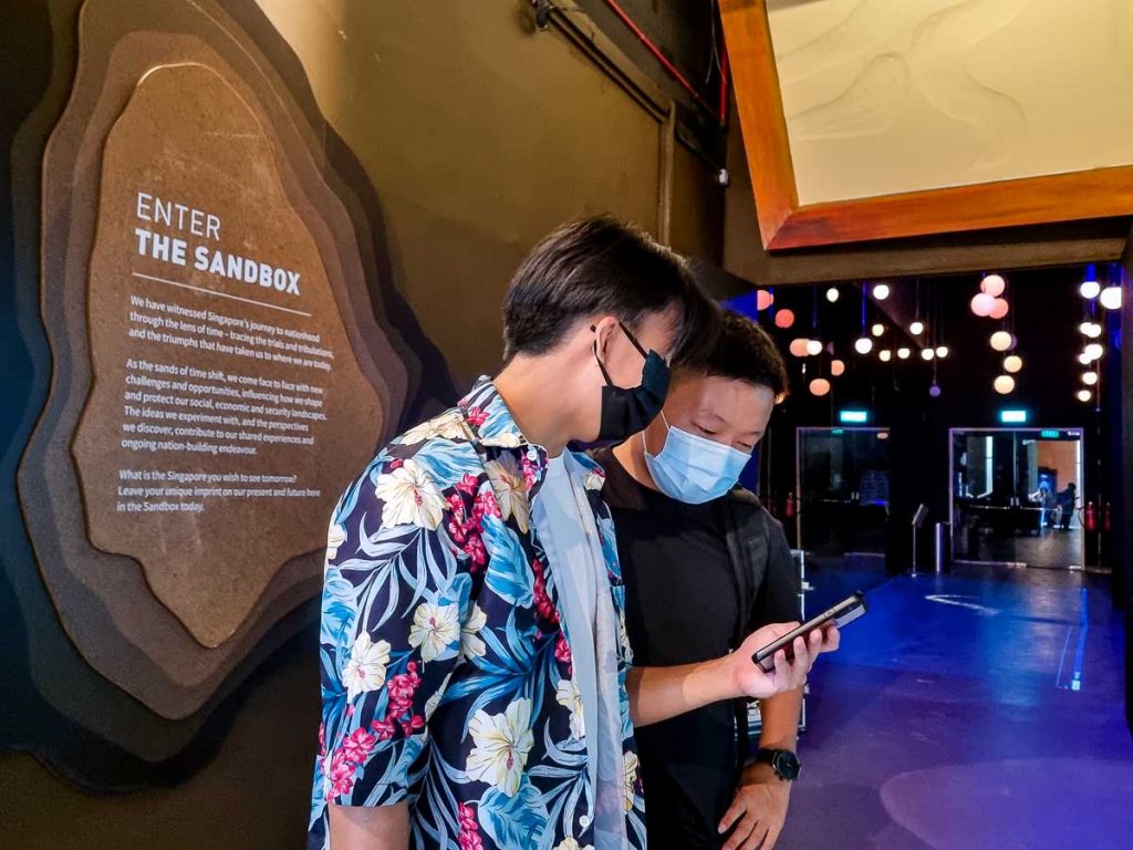 Timo and Choo looking at phone at Sandbox Gallery - Things to do in Singapore Discovery Centre