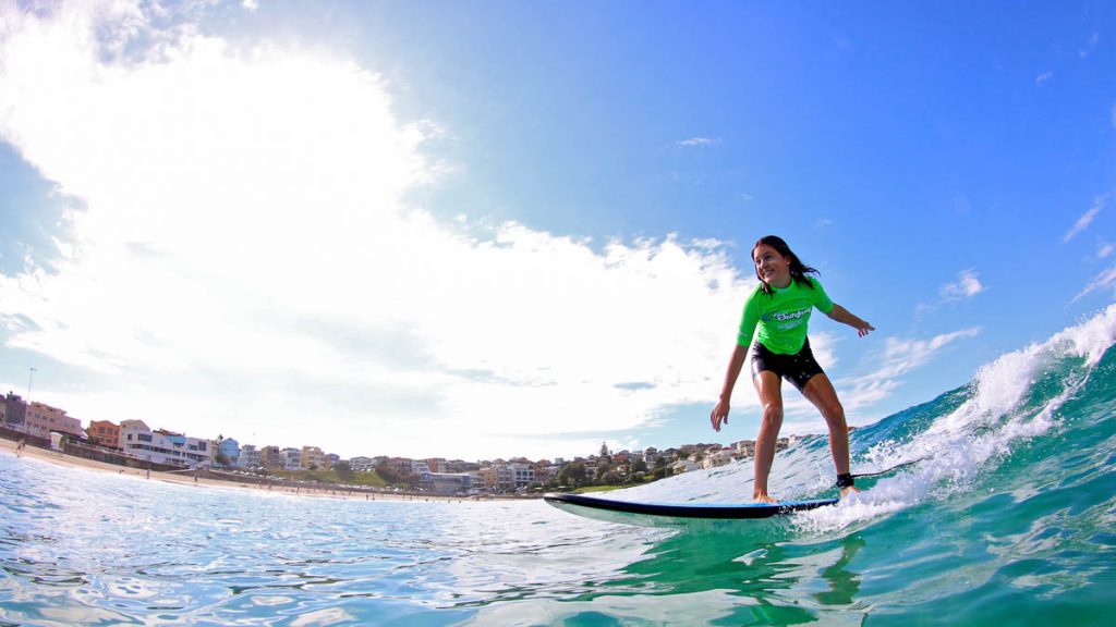 Girl surfing at Bondi Beach with Lets Go Surfing - Sydney New South Wales