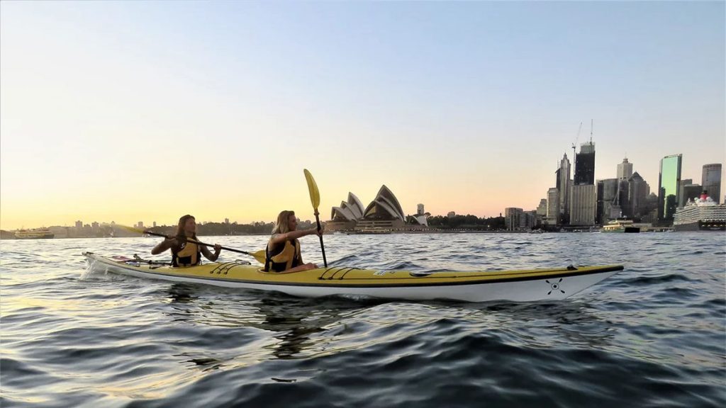 Girls on a double kayak on Sydney Harbour at sunrise