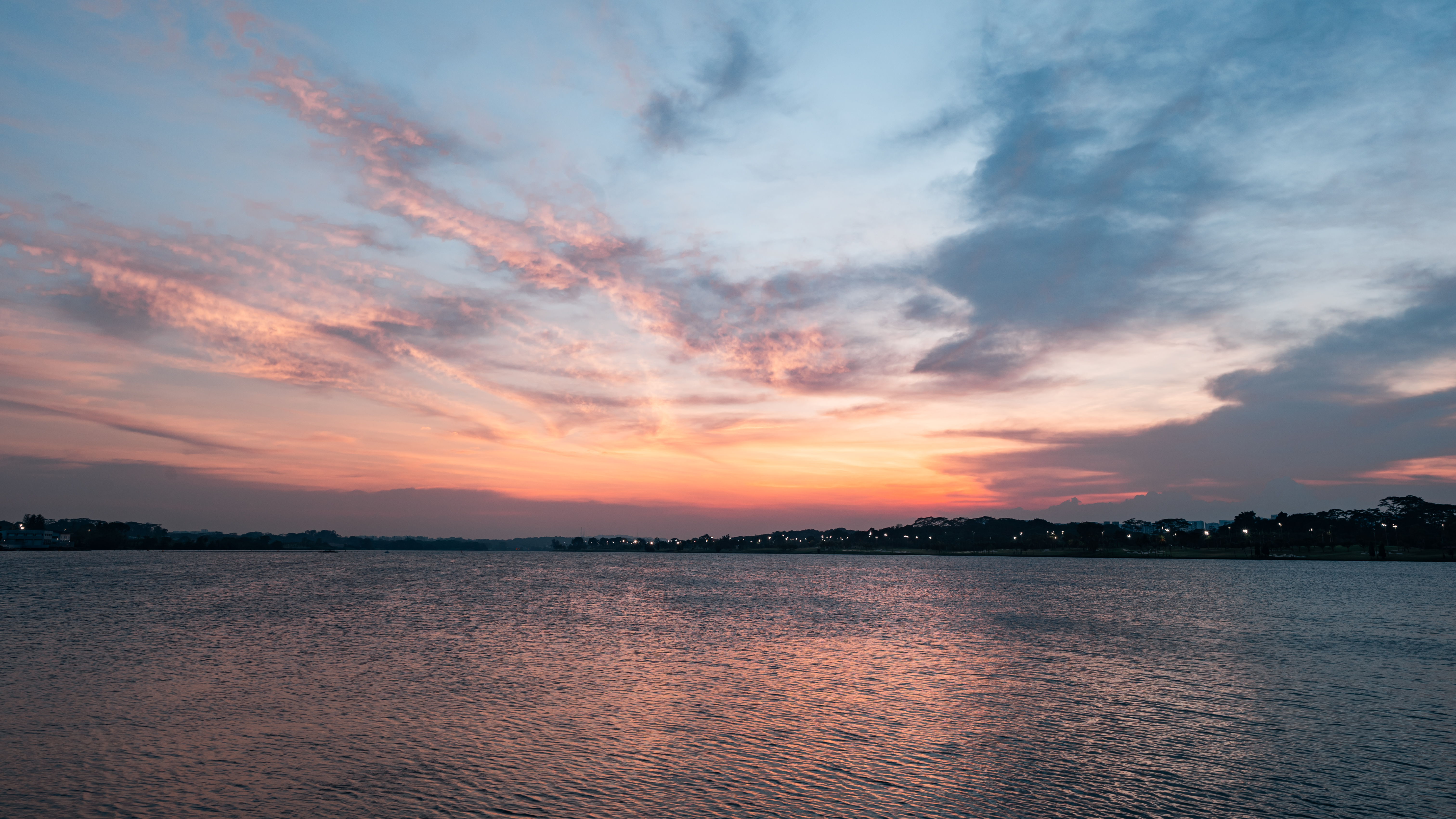 Sun setting over the horizon with orange sky - Night Cycling Singapore