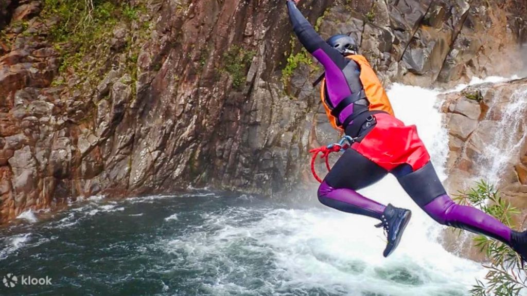 Person Canyoning Near Waterfall - Queensland Adventure