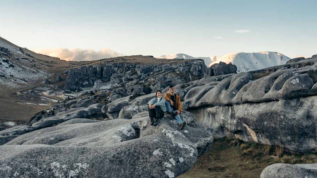 Arthurs Pass Kura Tawhiti Castle Hill People Sitting on Boulders - New Zealand South Island Guide