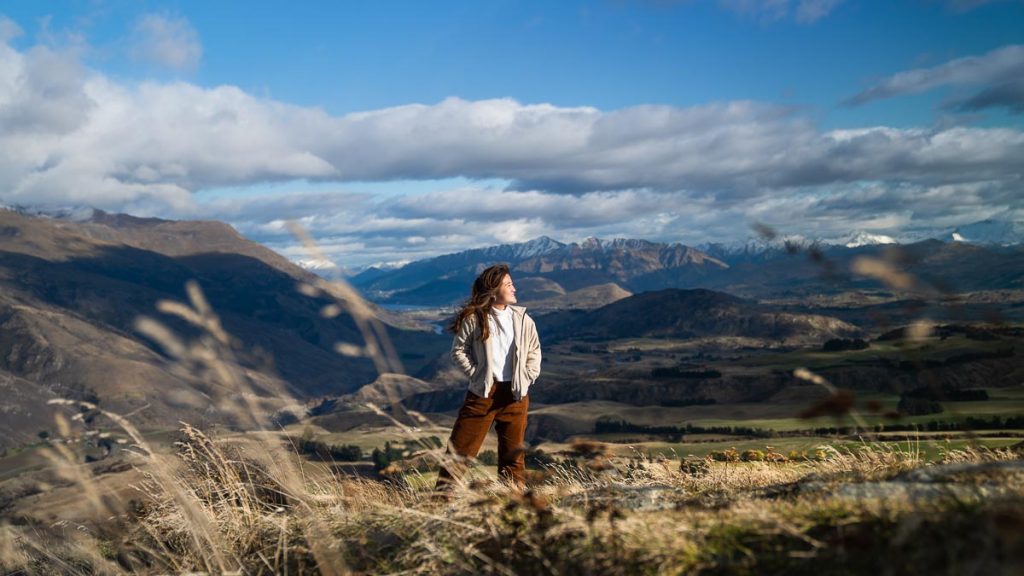 Girl posing in open grassland - New Zealand South Island Itinerary