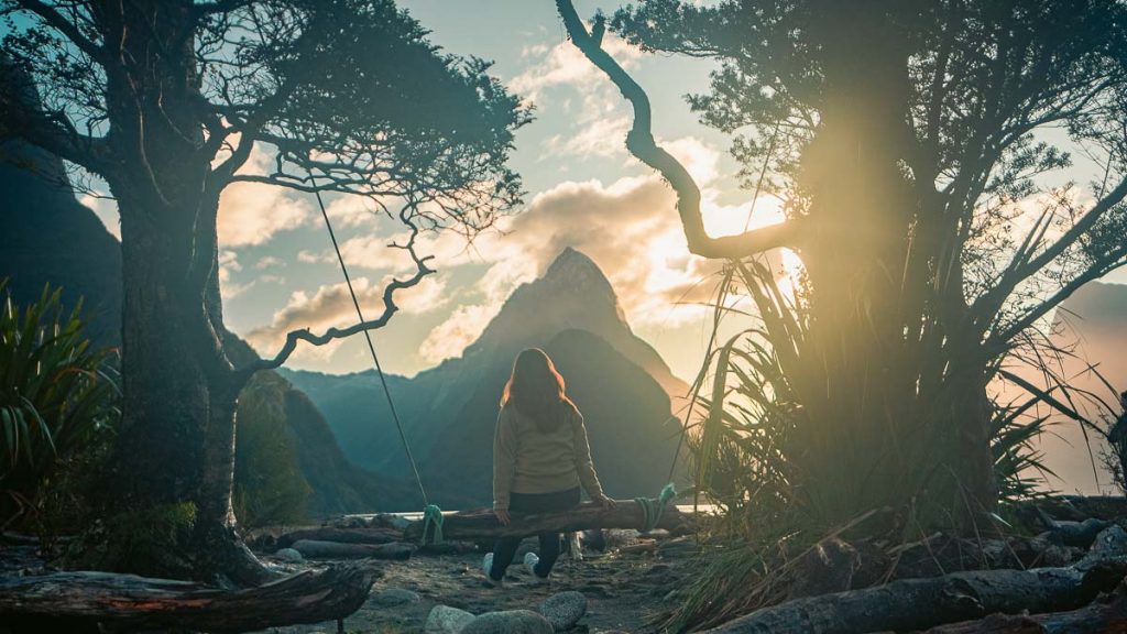 Girl sitting on Milford Sound Swing - New Zealand South Island Itinerary