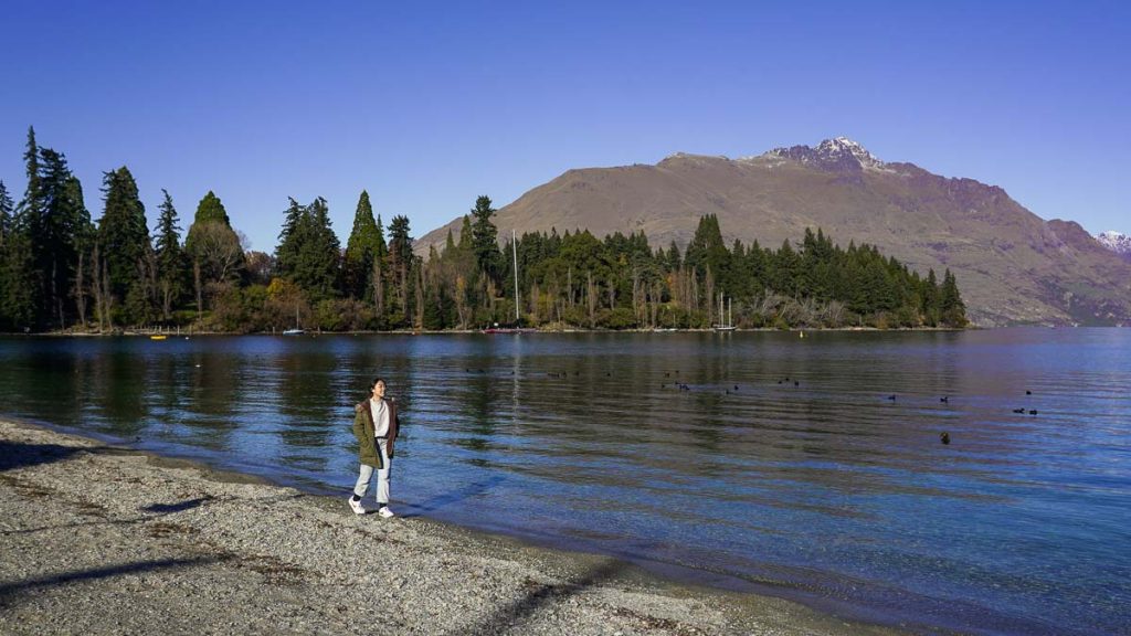 Girl walking along Lake Wakatipu lakefront - New Zealand Queenstown