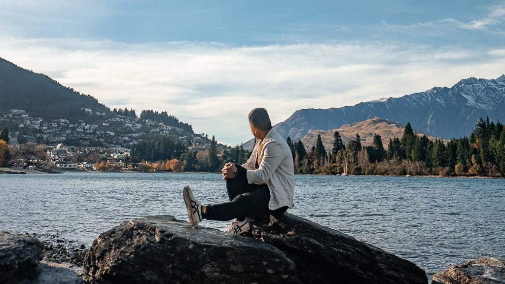 Queenstown Lake Wakatipu Person Sitting on Rock - New Zealand South Island Guide