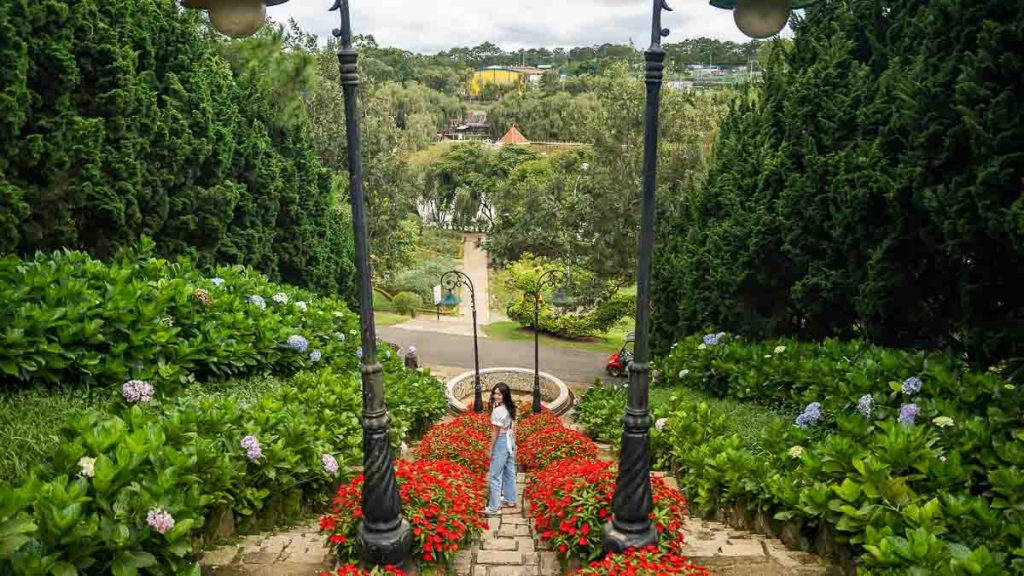 Girl standing amidst flowers at Da lat Flower Park - Things to do in Southern Vietnam