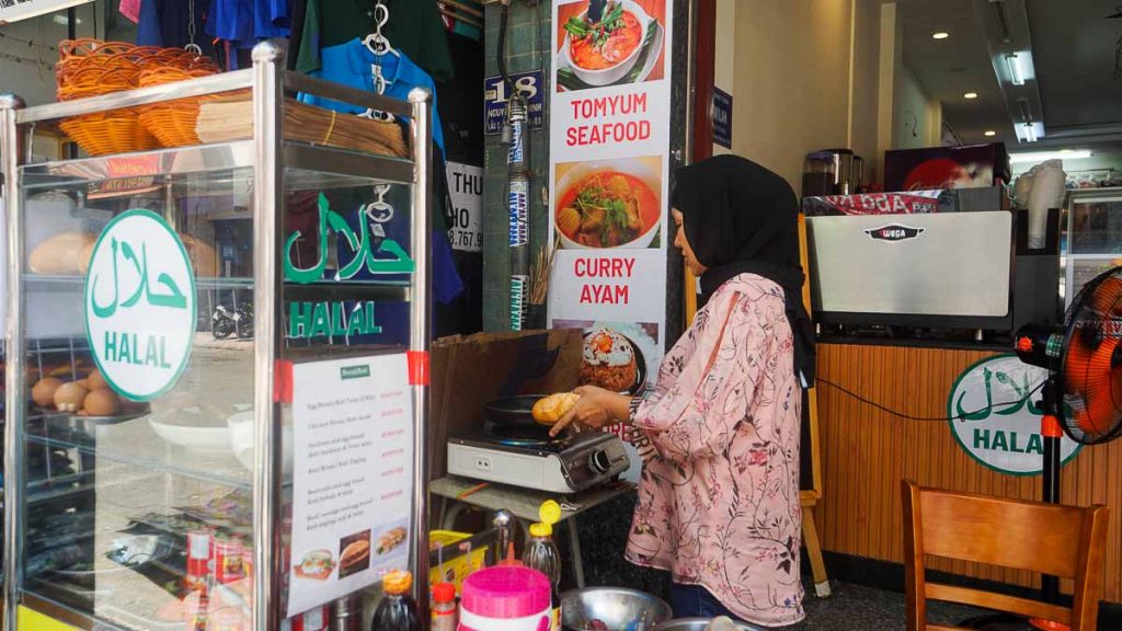 A lady preparing halal bahn mi at malaysian street - ho chi minh guide