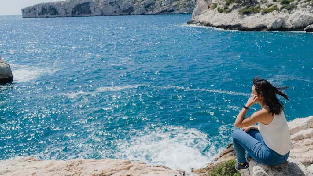 Woman looking at the sea in France Sugiton Calanques beach Marseille - Budget Travel tips