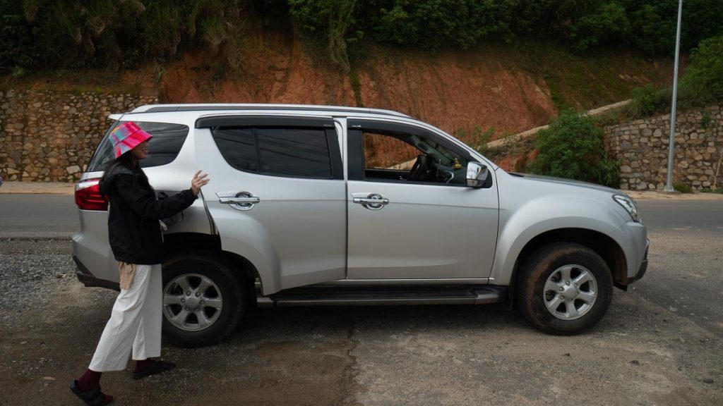 Girl entering private car charter on the roadside in Da Lat Vietnam - getting around vietnam