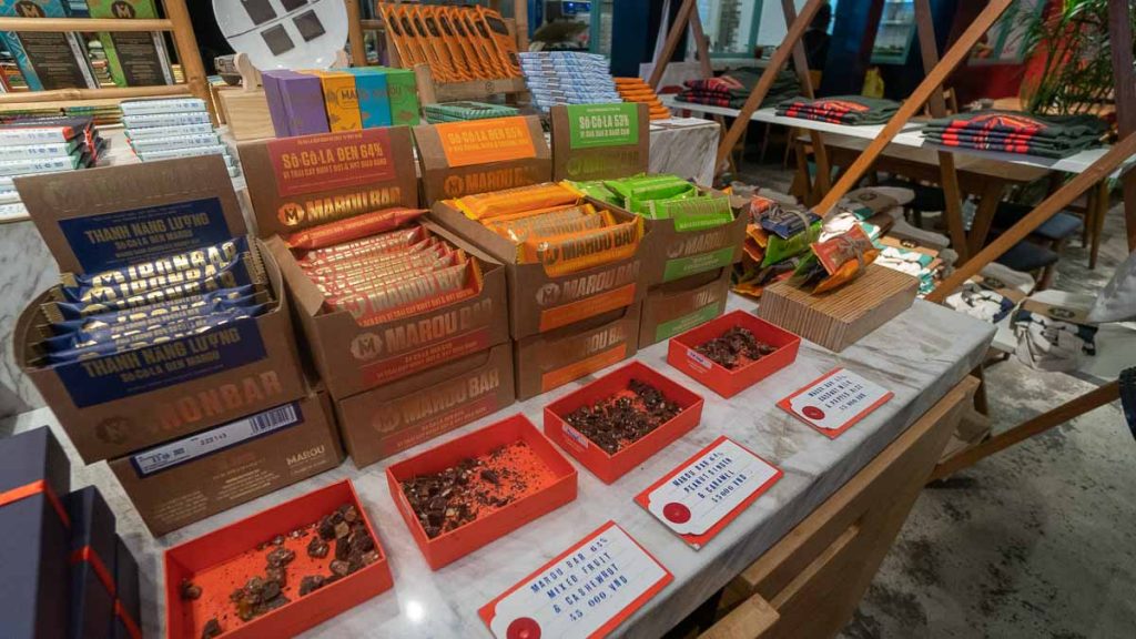 Thick bars of chocolate in colourful packaging with samples in front - Things to do in Ho Chi Minh