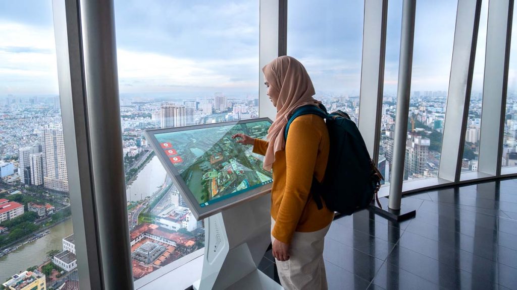 A girl in a hijab using the interactive map at Saigon Skydeck - Things to do in Ho Chi Minh City