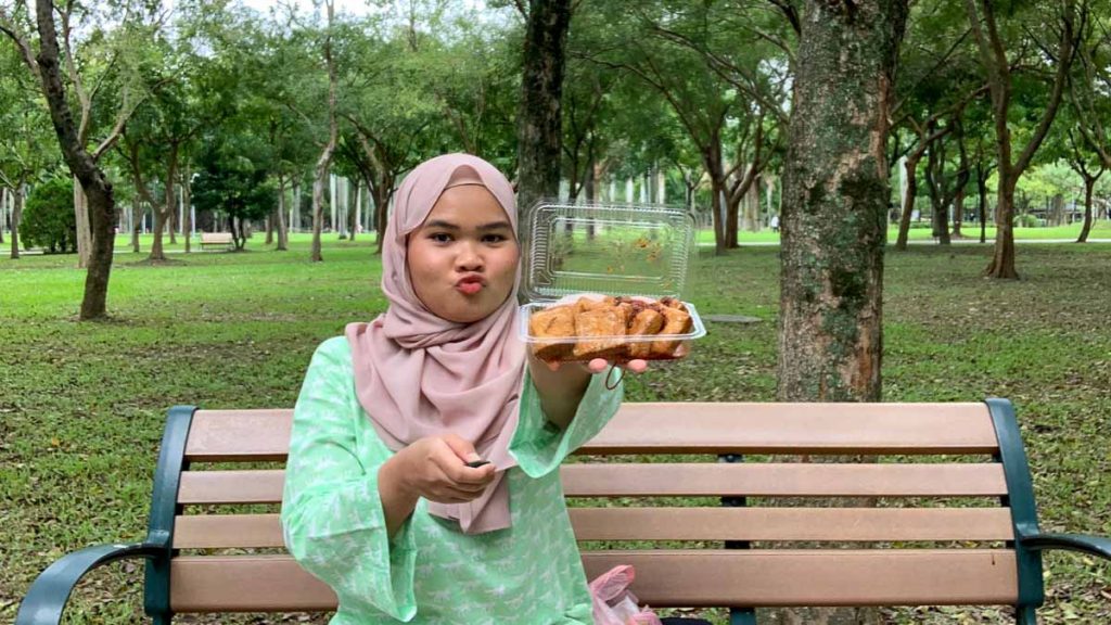 Girl in Hijab posing with braised tofu in Da'an Park - Solo travel Taiwan