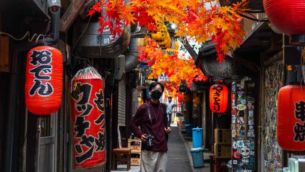 Man standing in the middle of Japanese alley