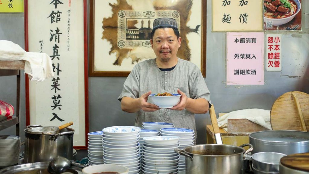 man serving noodles soup in Halal Yellow Beef Noodle House - food in Taipei