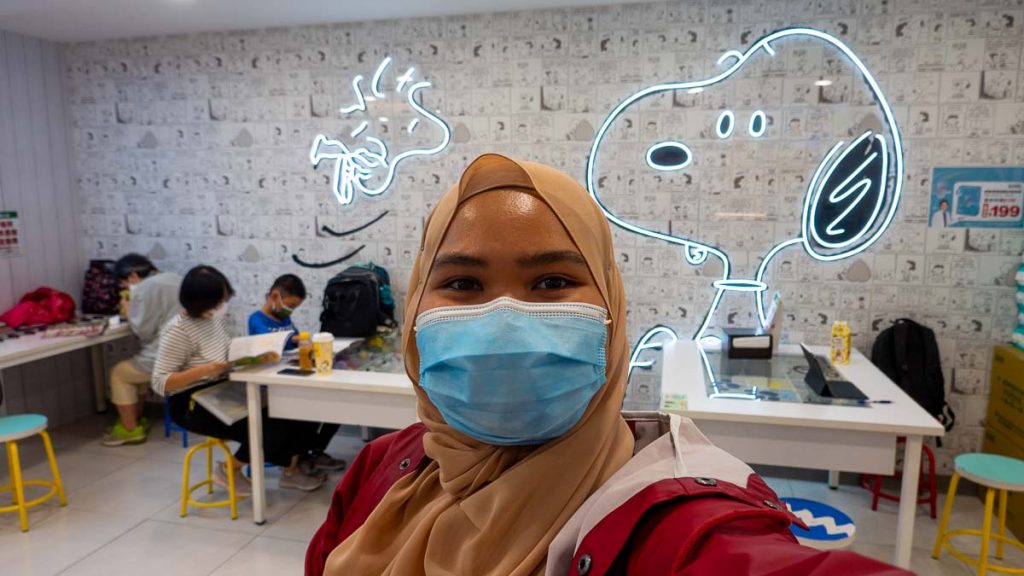 girl taking a selfie in a snoopy themed 7-11 - Solo Travelling in Taiwan For Muslims