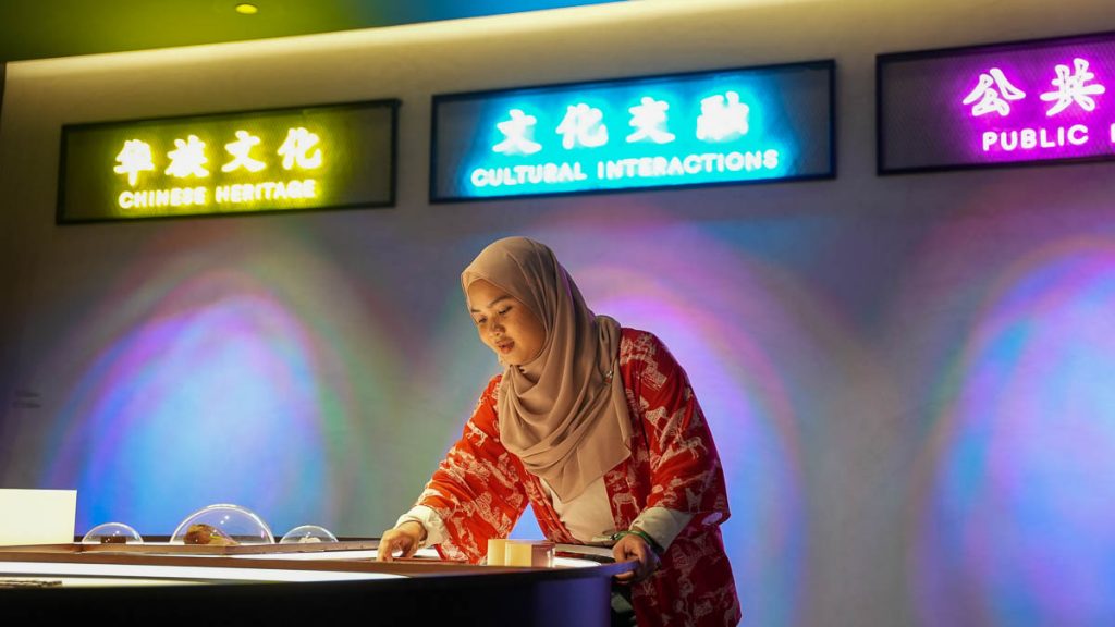 Girl interacting with exhibition materials at the Singapore Chinese Cultural Centre - thomson-east coast line