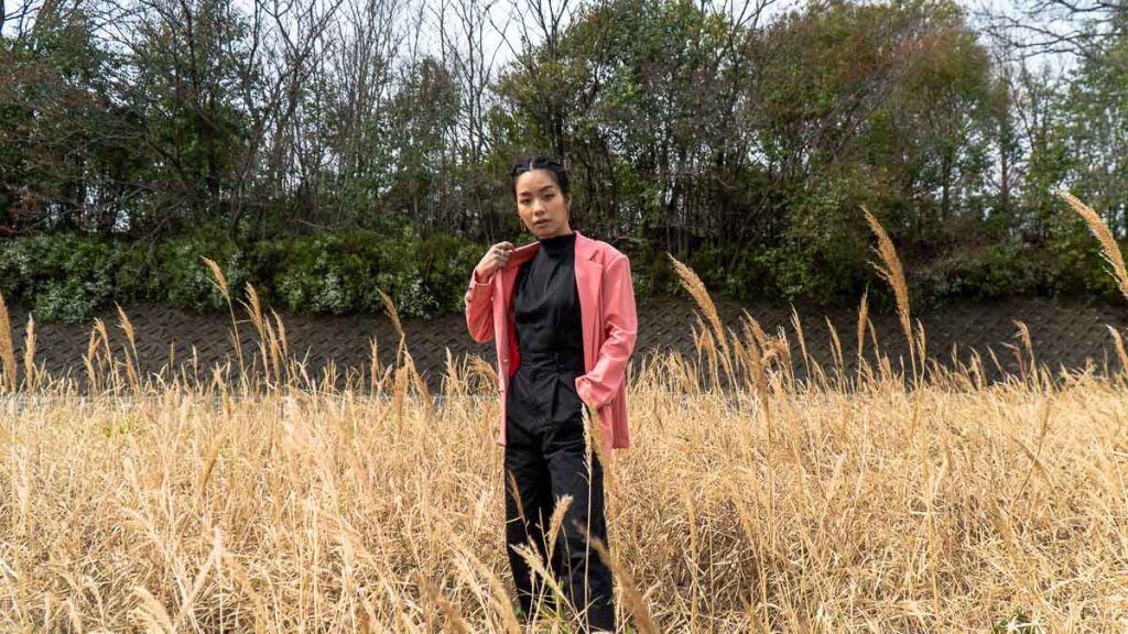 Girl in pink blazer in a wheat field - Travel Outfit Ideas