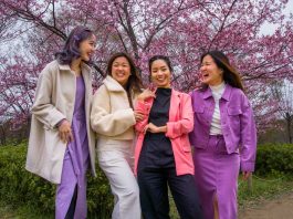 Group of girls laughing under sakura trees in Japan