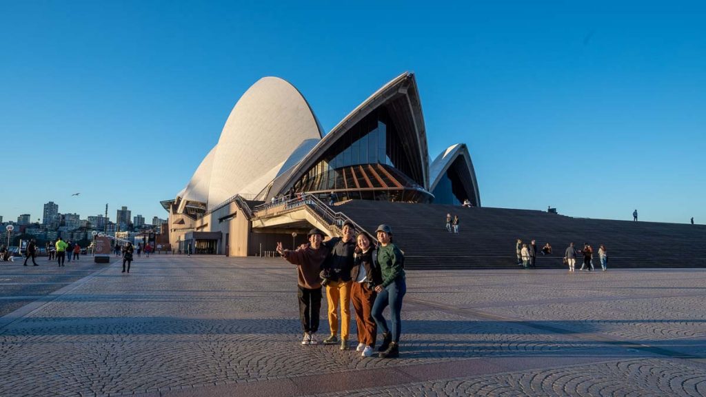 Friends taking a photo in front of the Sydney Opera House - Things to do in Sydney